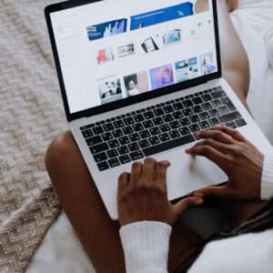 person using macbook pro on brown textile